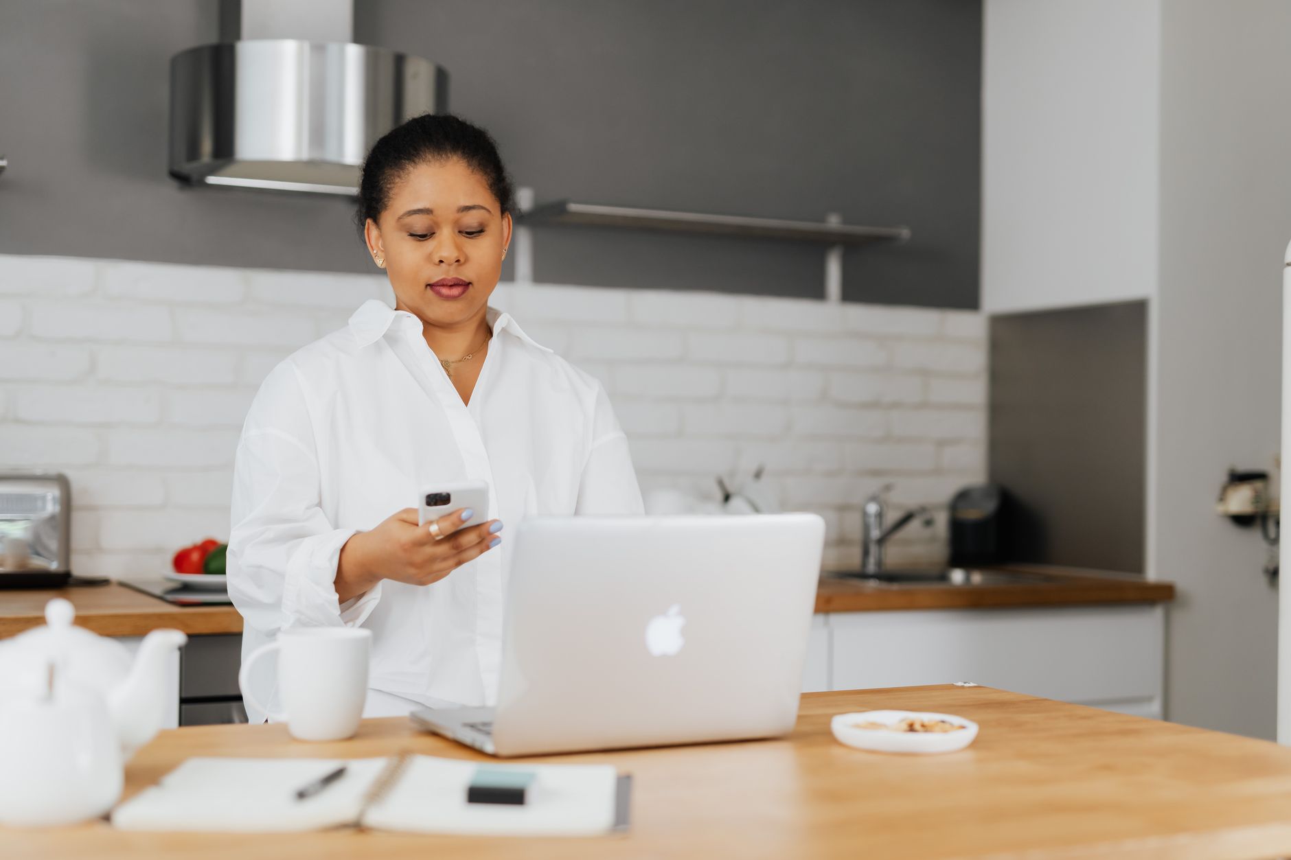 a person reading a suspicious email on a laptop at a kitchen table