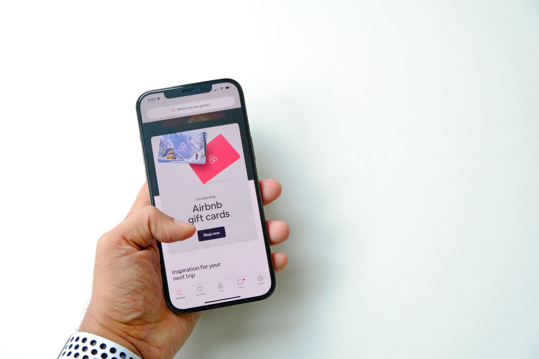 hands holding several retail gift cards beside a smartphone