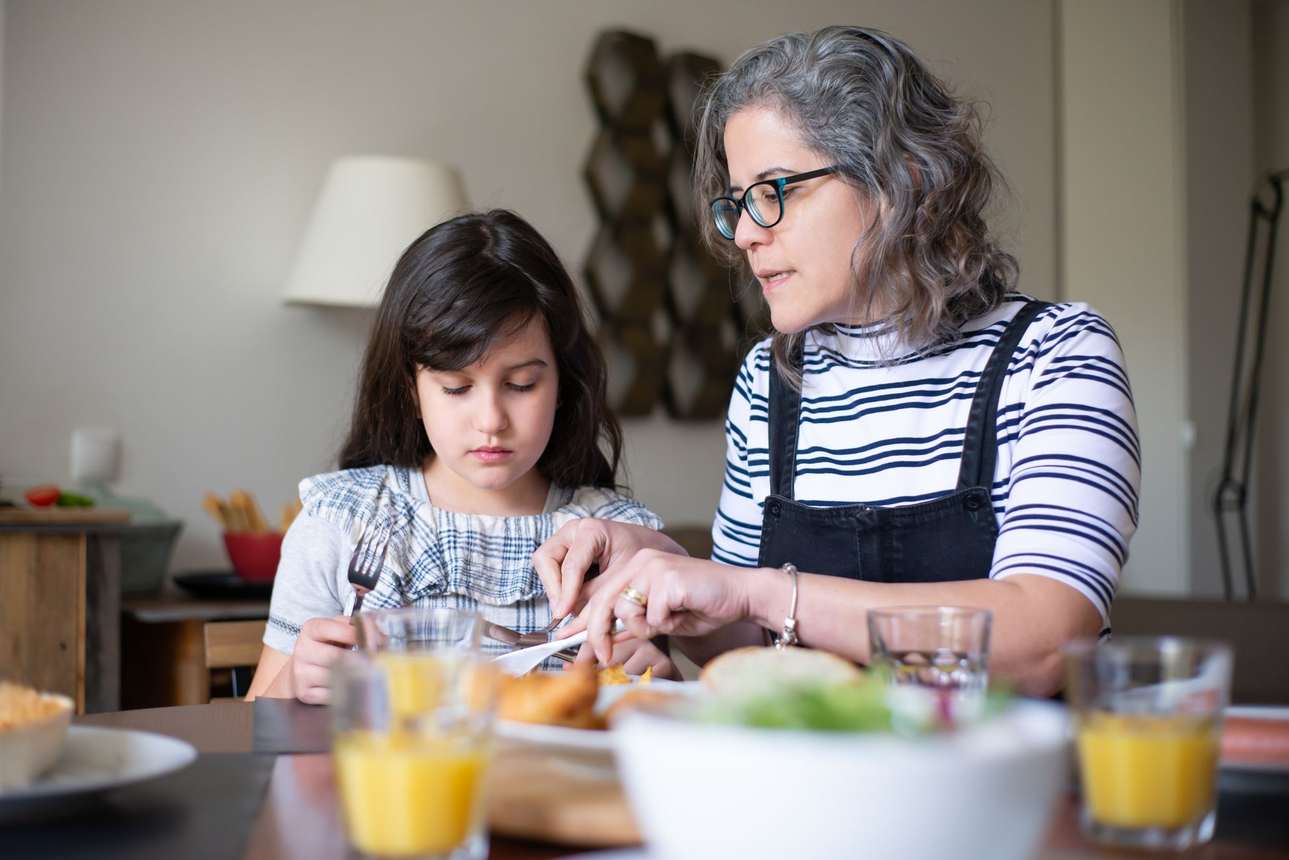 adult daughter and elderly mother talking calmly at a kitchen table