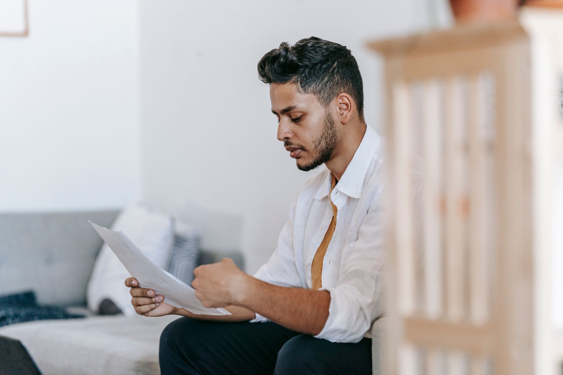 a person shredding papers with personal details at a home desk