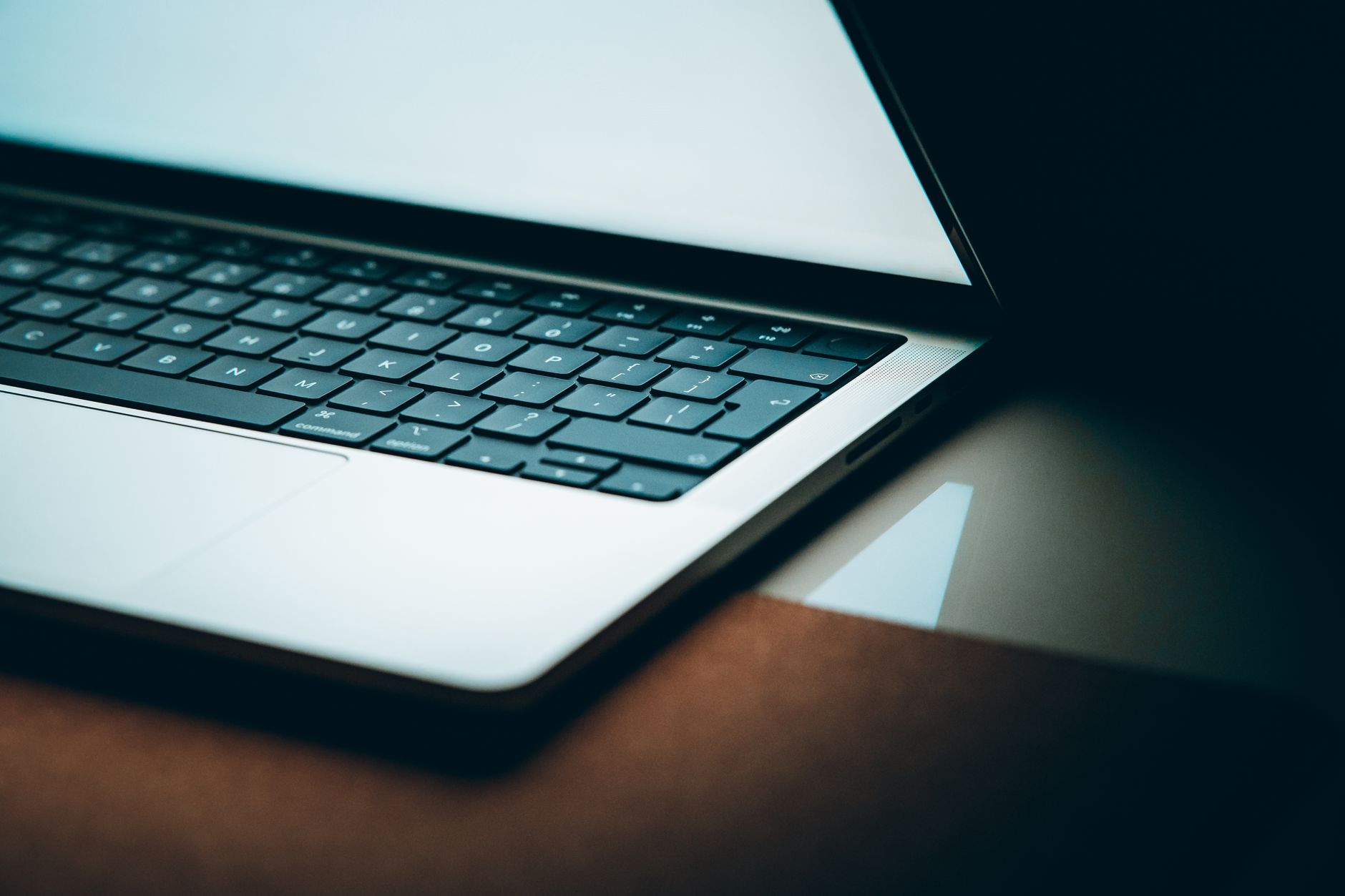 A laptop screen displays a suspicious email with a forged sender name in an inbox.