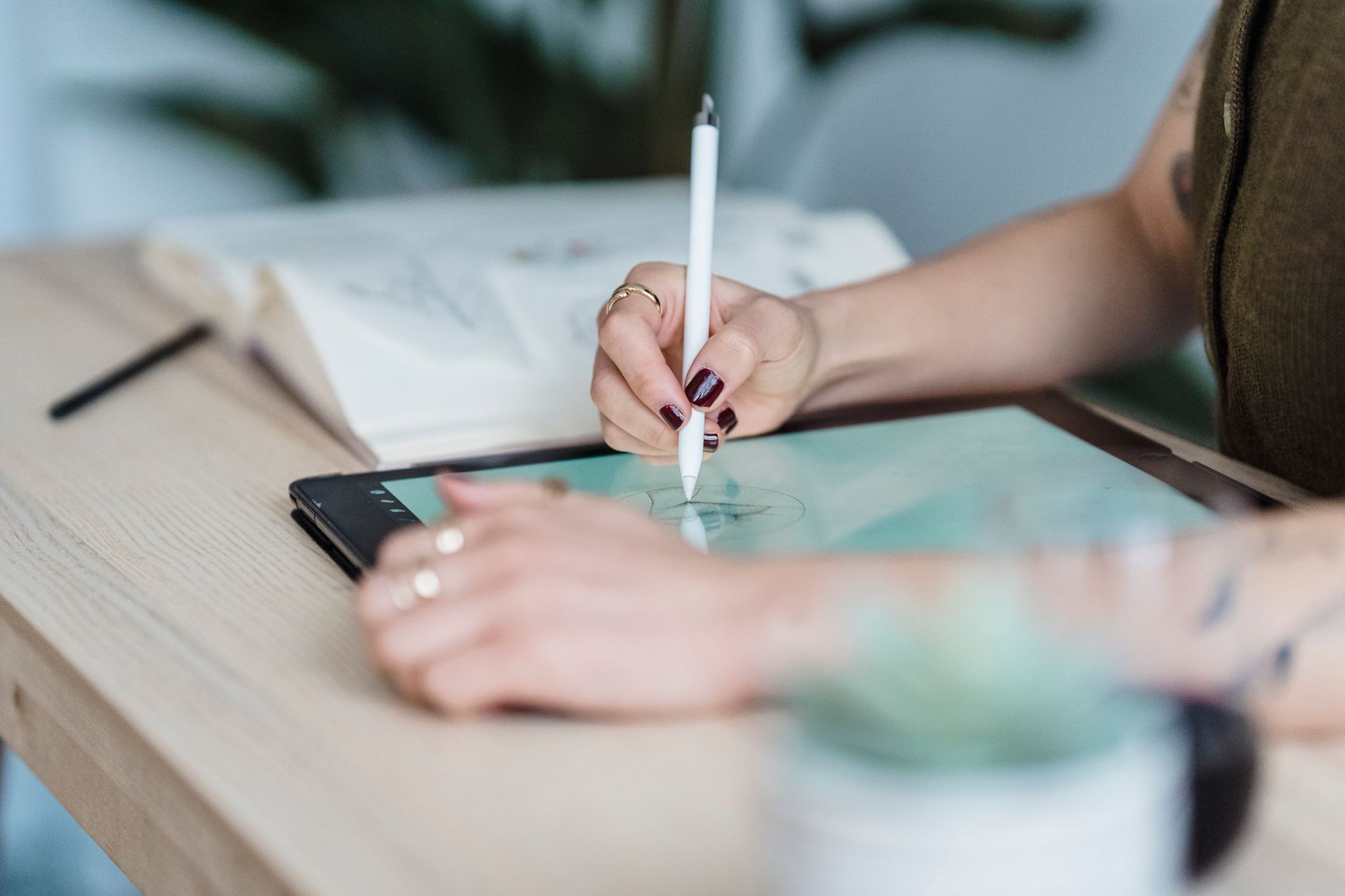 A digital artist working with a drawing tablet in a bright home studio.