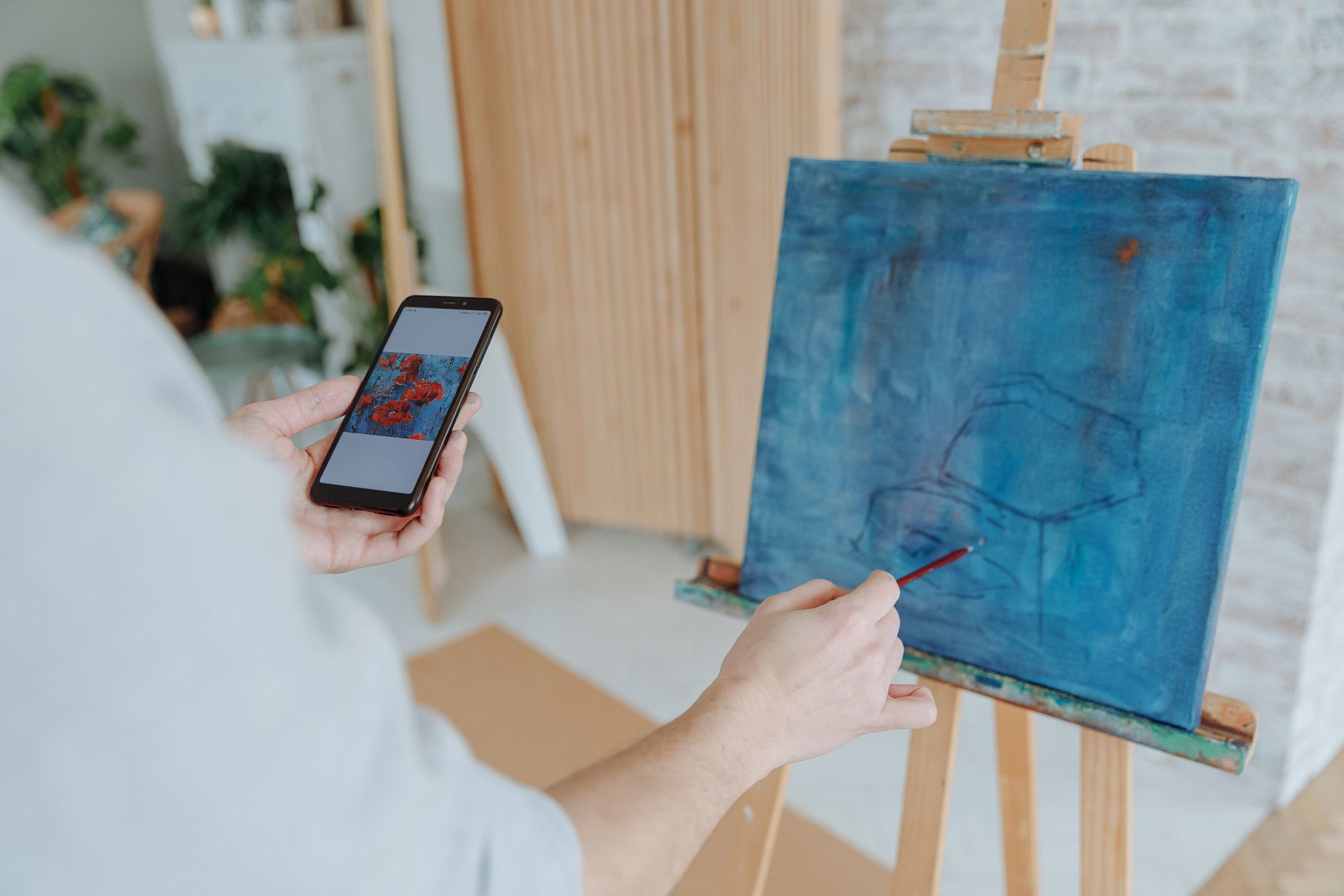 An artist uploads digital artwork from a laptop to an online portfolio site.