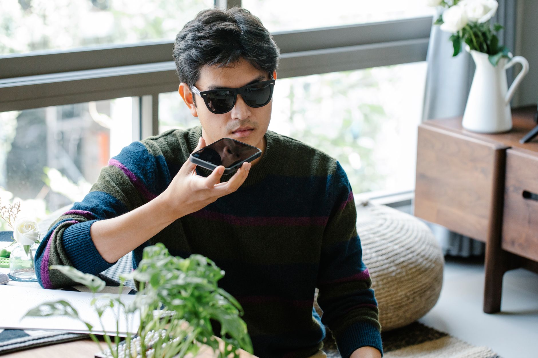 Person looking at smartphone with worried expression during a phone call